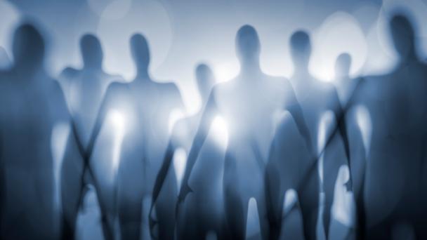 Out-of-focus alien shapes in front of a bright light